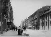 Drottninggatan mot söder. Fotot är taget bortom Nikolaikyrkan. Till höger syns gamla prästgården (numera platsen för Länssparbankens hus).
Pojken närmast med ryggen mot kameran heter Ossian Odler (1895-1978) tillsammans med mamman Anna Olsson.