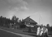 Bostadshus, sex personer framför huset.Karl Hedström, m.fl.Dalarna