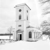 Brevens kyrka den 23 mars 1937. Kyrkans torn är i blickpunkten framför den snöklädda kyrkogården.