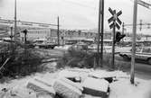Trafik vid järnvägsövergången vid Labackavägen i Kållered, år 1984. I bakgrunden affärsbebyggelse vid Bangårdsvägen.

Fotografi taget av Harry Moum, HUM, Mölndals-Posten, vecka 4, år 1984.

Bildtext:
