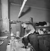 Lindbergs Strå- och Filth. Hattillverkning. 201/67 Formning av stråhatt.Med en pensel indrängt med en lösning av sprit och schellack bestrykes hatten in- och utvändigt.