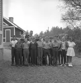 Löa skola, skolbarn med lärare på skolgården. Skolbyggnad i bakgrunden.
Magister Lennart Söderlund