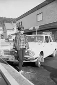 Siv Hjalmarsson står framför en Plymouth Valiant utanför EPA på Kungsgatan i Huskvarna.