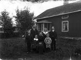 Familjebild.Familj fotograferad utanför sitt hus.