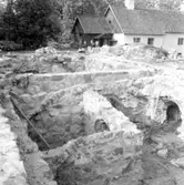 Kägleholms slottsruin (Kägleholm) den 9 juni 1937. Ett utgrävnings- och restaureringsarbete pågår av källarruinen till Kägleholms slott. Närmast syns källarruinen med sina murar, valv och portar. Lite längre bort syns några arbetare framför den norra slottsflygeln. Kägleholms slottsruin skall så småningom beläggas med trätak.