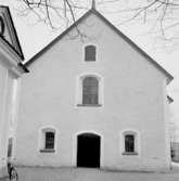 Kräcklinge kyrka den 15 april 1937. Kyrkan sedd från gavelsidan med kyrkporten längst ner. Till vänster skymtar ett annex (tillbehörsbyggnad) till kyrkan.