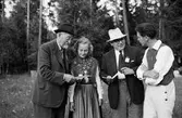 Ung kvinna och män vid spelmanstävling i Granebergsparken, Sunnersta, Uppsala augusti 1945