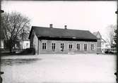 Tomten för nya skolbygget från Botvidsgatan. Gamla Biblioteket och transformator. Vy från skolgården före 1949.