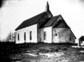 Gökhems kyrka. Skorstenen i form av ett kyrktorn, togs bort 1946-47 då man satt in eluppvärmning. Till höger syns skolhuset.