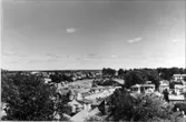 Utsikt från kyrktornet mot sydost över stora torget, kv.Boktryckaren, Hästbacken med småstugorna. Till höger kv. Bagaren (Blomgrens), Trätorget, Gamla kyrkogården och kv. Vagnmakaren.