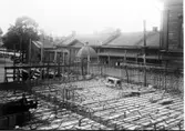Falköpings centralstation under byggnad. Kupolen i mitten av bilden är Pressbyråns kiosk. Innehavare av denna var kontorsbiträdet Klein. Där bakom matsalar m.m. Byggnaden till vänster var poliskontor jämte arrestlokal (låg åt bangården), vidare var där toaletter för kvinnor och män samt smörj- och lamprum.