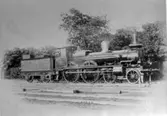Lokomotiv på Falköpings bangård. Ett lok med tender från förra århundradet. I förarhytten synlig lokf. A.E. Alexandersson.