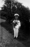En liten pojke i sjömanskostym, med blombukett.
Stig Karlsson, född 1924.