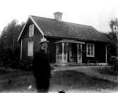 En man. Envånings bostadshus i bakgrunden.Andersson i Lövdalen.