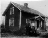 Bostadshus, familjegrupp  fem personer framför huset.
Henning och Teckla Undén med sina barn.