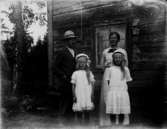 Bostadshus, familjegrupp fyra personer framför huset.
Sven Thunberg med hustru Sigrid och deras två döttrar.