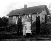 Gjutarebostaden, envånings bostadshus, familjegrupp fem personer framför huset.
Fru Karlsson med dottern Ingeborg, och sönerna Knut, Karl och Ivan.