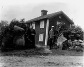 Tvåvånings bostadshus, ett äldre par framför huset.
Lars-Erik och Augusta Kristina Olsson, Erik Theon Olssons föräldrar.