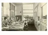 Interiör av solverandan på 3 B, Kustsanatoriet Apelviken. Personal och patienter i sina sängar.
