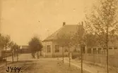 Kvarteret Österbro, kvarteret Hammaren nummer10 (31) hörnfastighet i mitten, foto från NO mot SV omkring 1892, foto: B P Bengtsson, 3494, i förgrunden Hantverkargatan. Snett mitt för denna fortsätter Gjutaregatan, i vars bortre ända nedre bangården går fram, med godsmagasinet (som förr var stationshus) främst. Mitt på bilden ligger konsul Georg Petersens bostadshus och till höger om detta ett äldre hus som möjligen tjänstgjort som bostadshus åt föräldrarna fabrikör J C Petersen och hans maka? Till höger i förgrunden ser man (innanför stängslet9 tomt nr. 12 (212 Ub2?) kvarteret myran och i framkant till vänster tomt nr. 13 (29Be?) kvarteret svanen.