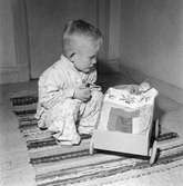 Tom Andersson i sitt hem på Odengatan 22 i Huskvarna. Det är läggdags och han ber aftonbön tillsammans med sina nerbäddade dockor.