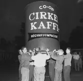 Några ungdomar bär på en reklamskylt för Cirkel kaffe.