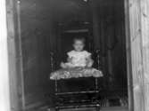 Barnporträtt. Ett barn fotograferat sittande i en 