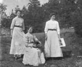 Gruppbild av tre kvinnor fotograferade utomhus.