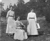 Gruppbild av tre kvinnor fotograferade utomhus.