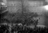 En mängd människor framför rådhuset, ”1919K” på asken
	Metallutfällning.