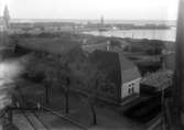 Stadsvy ”von oben” Stenkolsbolaget i förgrunden, hamnen i bakgrunden, ”vy 1917 F” på asken.