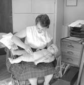 Rumsinteriör, en kvinna och en liten pojke.Siv Widman