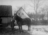 Man som håller en häst, en gård i bakgrunden, 1919
	Metallutfällning.