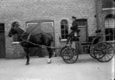 Häst och vagn, kusk i uniform 1915
	Metallutfällning.