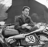 Världsmästaren i motorcross Rolf Tibblin står och lutar sig på motorcykeln.