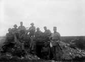 Första världskriget. Beväpnade soldater vid ett grävt skyddsrum eller liknande, år 1915.
	Metallutfällning, gula fläckar.