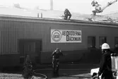 Brandkåren släcker brand i Bröderna Bäckmans industrilokal vid Gamla Riksvägen i Kållered, år 1984.

För mer information om bilden se under tilläggsinformation.