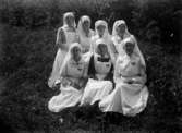 Sju sjuksköterskor som poserar (gruppbild) utomhus 1919
	Brun missfärgning i kanterna, prickhäl i emulsionen.