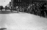 Cykellöpare, stor folkmassa möjligen ”Sverigeloppet”
	svag metallutfällning, repor.