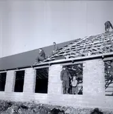 Byggnadsarbete på byggnad som blev Thuressons hönsfarm i Gillsätra, Glömminge. Företaget grundades av Sigvard Thuresson 1950. Idag drivs det av sonen Agne Thuresson och Yvonne Rydberg.