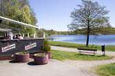 Vy från Restaurang Stensjön utöver Stensjön. Skyltar med 