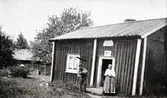 Man och kvinna utanför stuga.