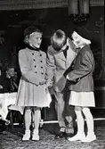 Firma AB N. Ekman. Modekavalkad 1954 i samband med firmans 90-års jubileum. Modevisning Stora hotellet. Bild 3: Kjol och blus våren 1954. Bild 4: Svängd kappa. Skiftande gul och svart bredrandig rips. Våren 1954 Bild 5: Dräkt och kappa årgång 1954. Mellanblå yllerips. Fru Hallgren Bild 6: Eva, Bertil och Marie. Barnbarn till dir. och fru Vilhelm Brandt. Bild 7: Flanschkappa (blåklintsblå). Bild 8: Vårdräkt 1954. Tweed.