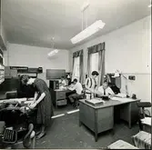 AB Papyrus. Byggnad 11, kontorsinteriörer. 25/5 1964. Fyra okända personer.