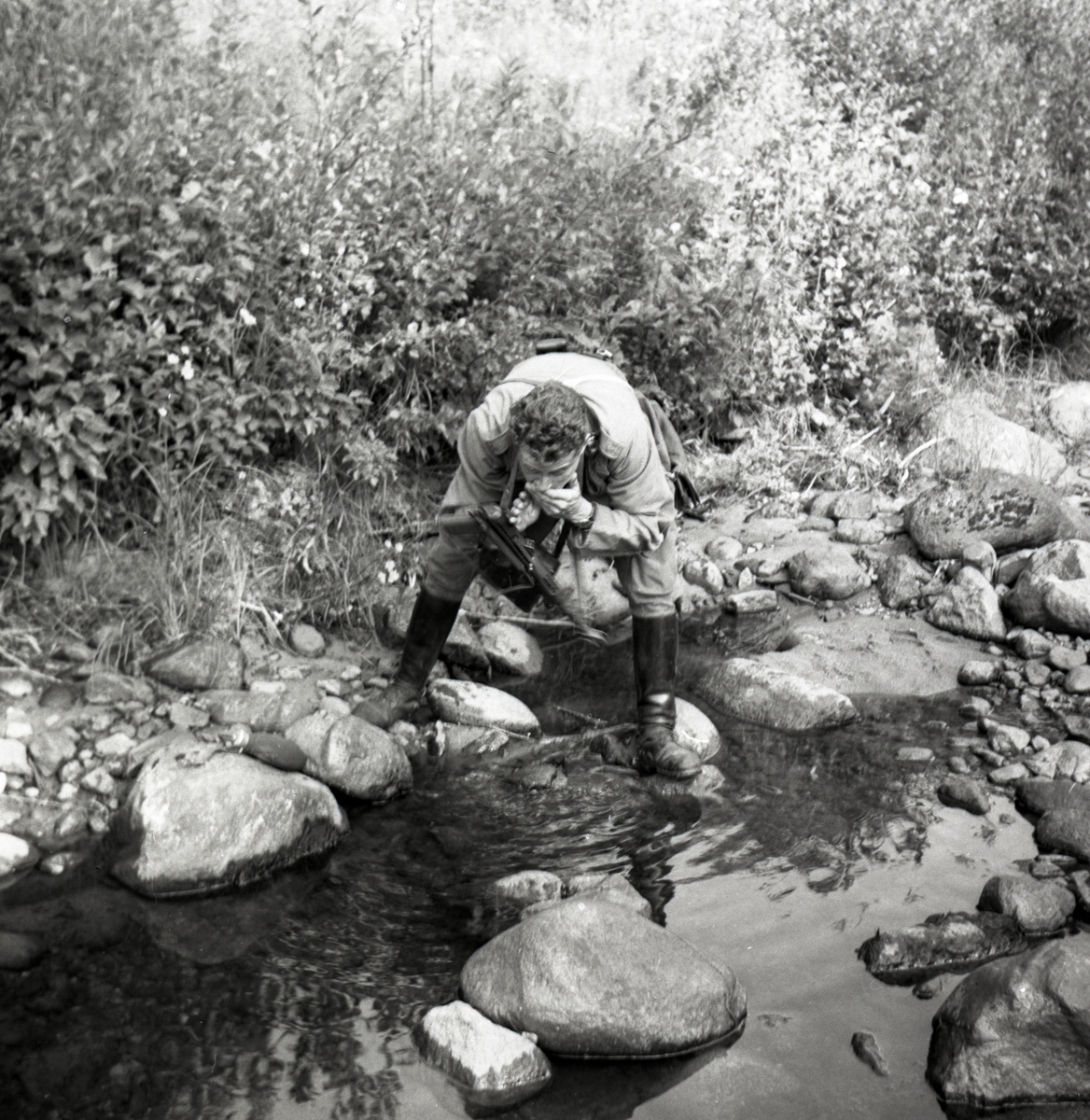 Bo Sallmander, Värnpliktig tvättar sitt ansikte vid en å. Norrlands dragonregemente K4, Umeå, 1955-1956.
