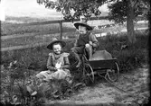 Lekande barn med tvåhjulig vagn.
Karl Bergström