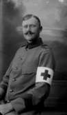 Man, röda korset ”1916 E” på asken, metallutfällning.