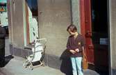 Lisbeth Sjöberg, dotter till Märta Sjöberg, fotograferad på trottoaren utanför Rasmussons skoaffär med adress Kvarnbygatan 4 vid Gamla Torget i Mölndal, ca 1961-1962. På trottoaren står även en sulky.

För mer information om bilden se under tilläggsinformation.