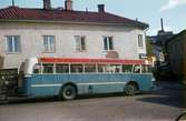 En blå buss framför huset Kvarnbygatan 45 vid Gamla Torget i Mölndal, 1960-tal. Till höger ses även del av Kvarnbygatan 6, byggnad tillhörande SOAB.

För mer information om bilden se under tilläggsinformation.