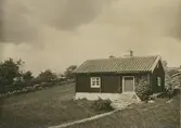 Arbetarstuga,ett  före detta  båtsmanstorp.
Änkefru Karlsson på Karlshöjd lär bland gårdens papper ha en del båtsmanskontrakt. Till höger Pettersson som bodde i torpet.